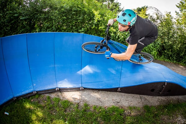 A rider surfs the berms of PARKITECTs modular pumptrack