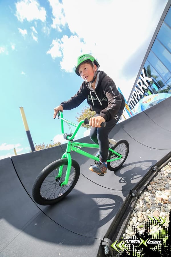 A youngster rides the berms of PARKITECTs modular pumptrack at an event put on my VSA Xtreme for Hot Wheels