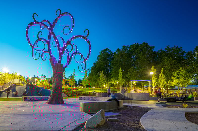 A whimsical looking tree lights up at night at Inspiration Playground, providing sensory delight. The playground is universally accessible and located in Bellevue, WA, USA.