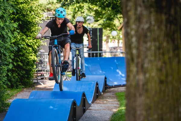 Bicycle riders going over rollers on a PARKITECT modular pumptrack