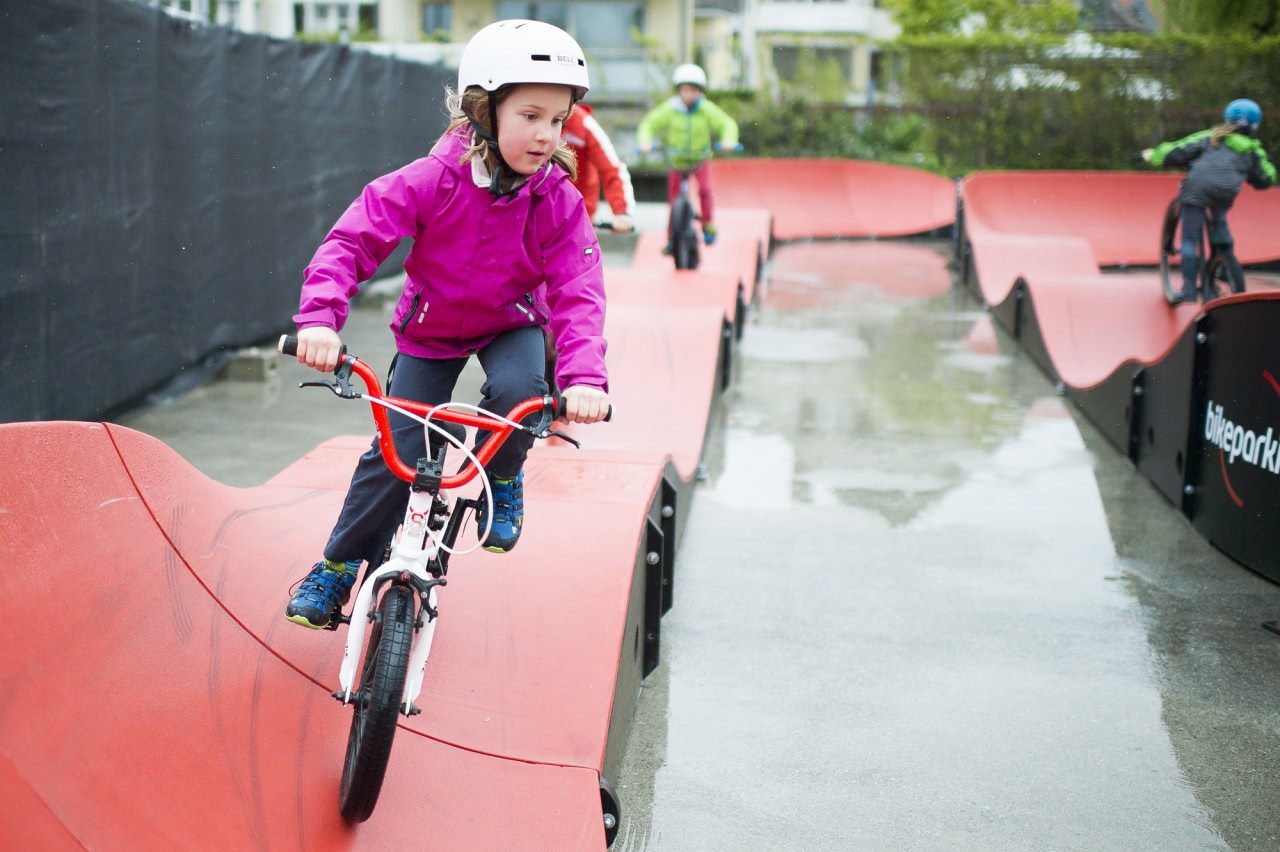 Child riding a PARKITECT modular pumptrack.