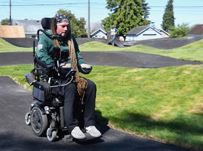 Man rides Port Angeles pumptrack in a wheelchair, first public adaptive track.