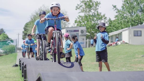 School aged children ride a modular pumptrack that is shared between four schools in West Auckland