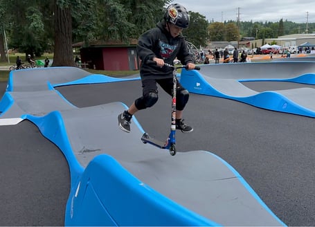 Young scooter rider does trick on Tenino Pumptrack
