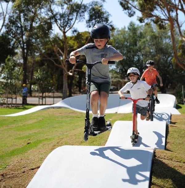 Three kids riding a PARKITECT precast concrete modular pumptrack in Wudinna, Australia