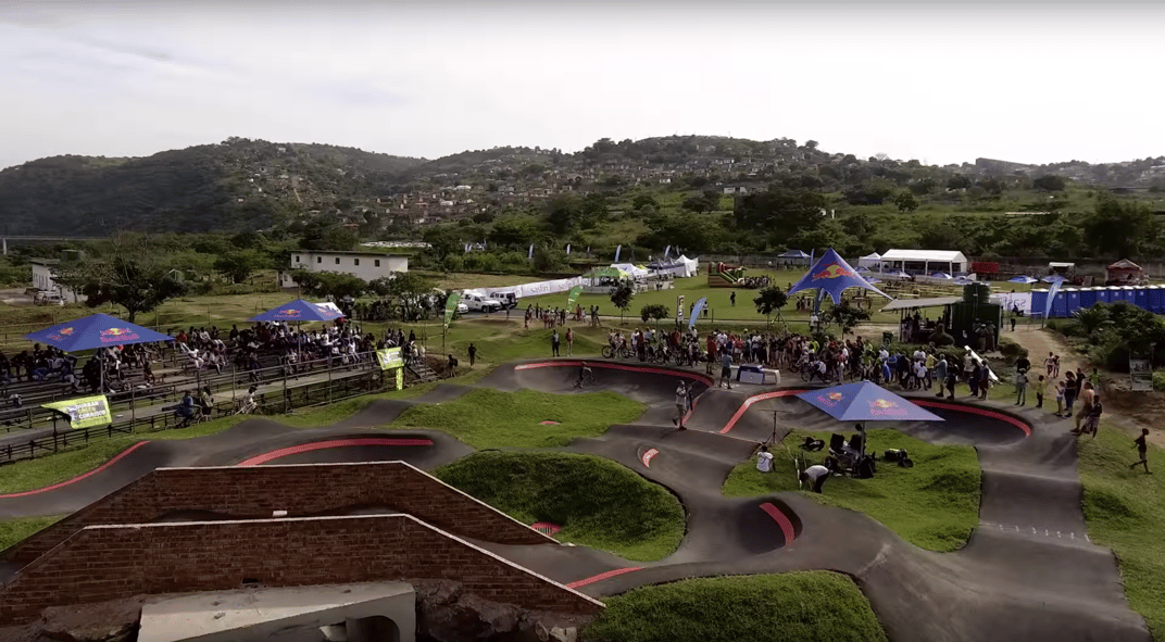 With its strong mission-driven purpose and unique design (ten berms, a tunnel and bridge) the Velosolutions pumptrack in the township of Kwadabeka, Durban, South Africa is on our list of pumptrack destinations. Courtesy Velosolutions.
