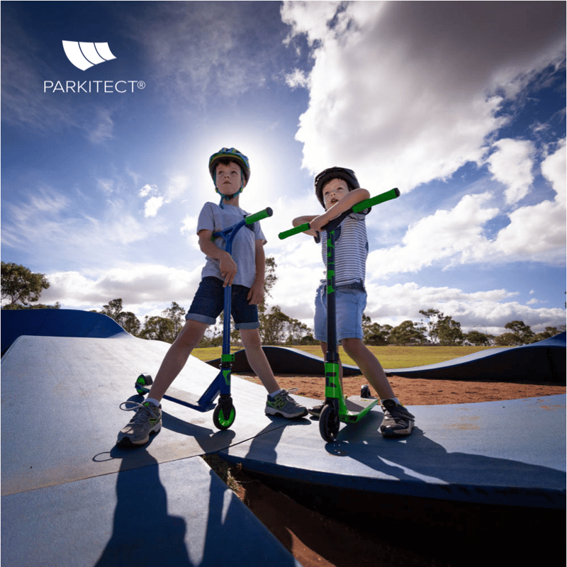 Kids enjoying a PARKITECT modular pumptrack on their razor scooters.